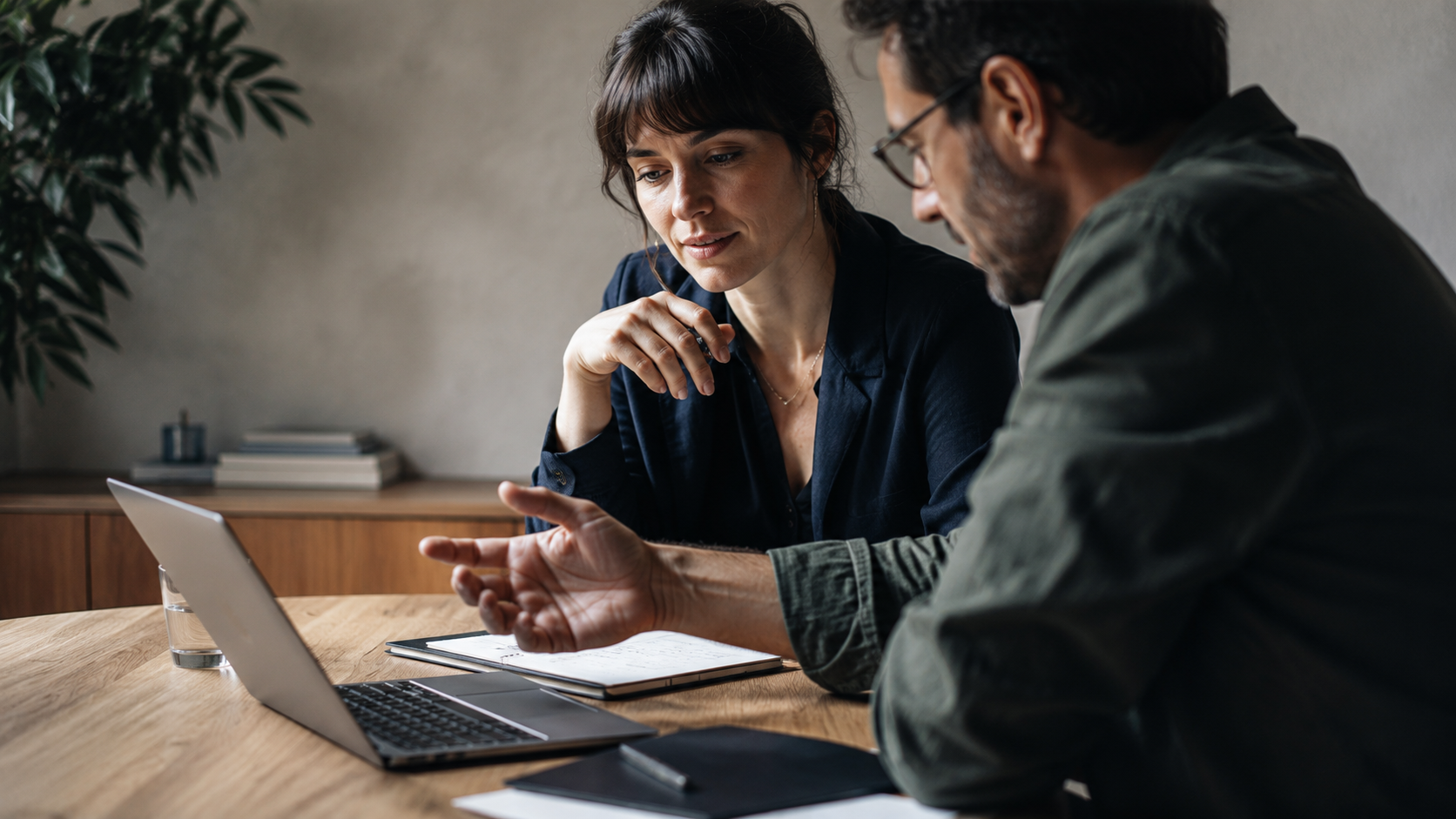 Adviseur en ondernemer bespreken samen een AI-plan achter een laptop